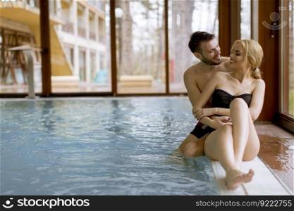 Loving young couple relaxing in the spa center by swimming pool
