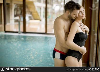 Loving young couple relaxing in the spa center by the swimming pool