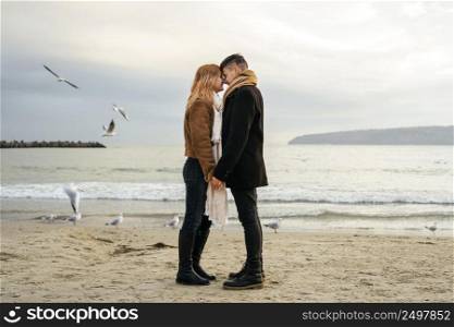 loving young couple winter by beach holding hands