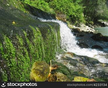Low and wide waterfall. Abhazia travel