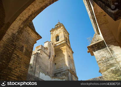 Low angle arch view of tower of Medina Sidonia church, Andalucia, Spain