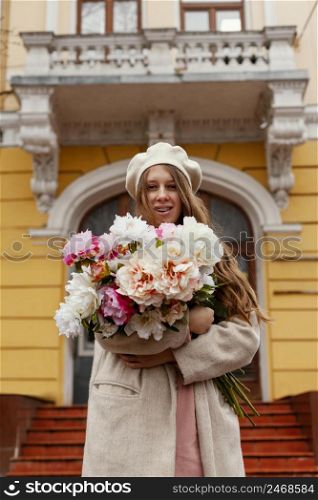 low angle beautiful woman holding bouquet flowers