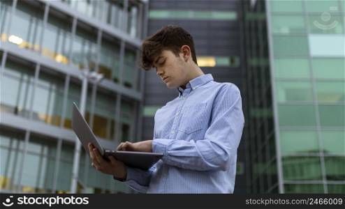 low angle boy holding laptop