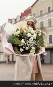 low angle elegant woman outdoors holding bouquet flowers spring 2