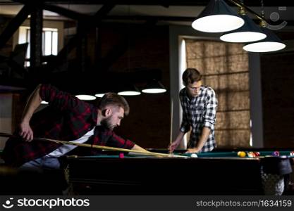 low angle guys playing billiard club