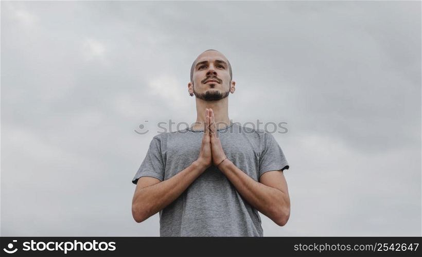 low angle man outdoors doing yoga