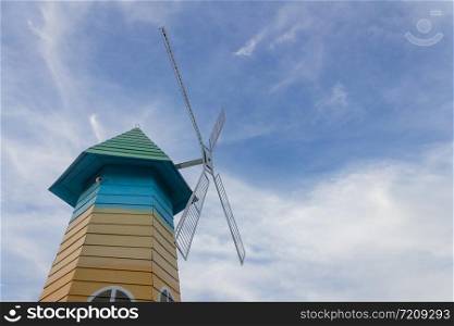 Low angle of wood windmill, clouds, blue sky
