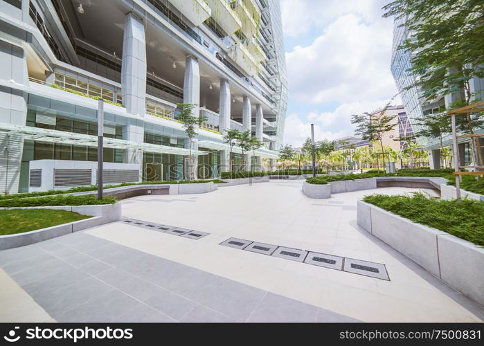 Low angle perspective view of empty pavement and modern office building with green eco concept .