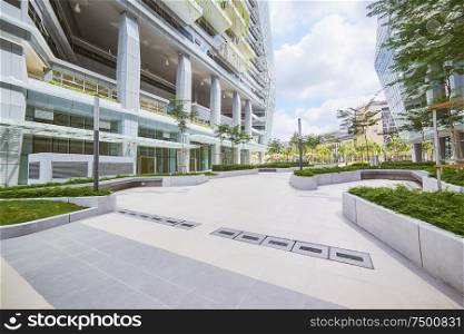 Low angle perspective view of empty pavement and modern office building with green eco concept .