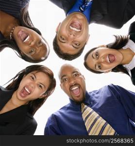 Low angle portrait of multi-ethnic business group of men and women in huddle screaming.