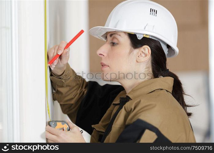 low angle shot of female carpenter working with spirit level