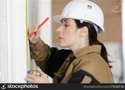 low angle shot of female carpenter working with spirit level