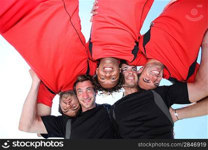 Low-angle shot of five young men playing rugby