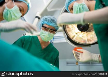 Low Angle Shot of Professional surgeons team performing surgery in operating room, surgeon, Assistants, and Nurses Performing Surgery on a Patient, health care cancer and disease treatment concept