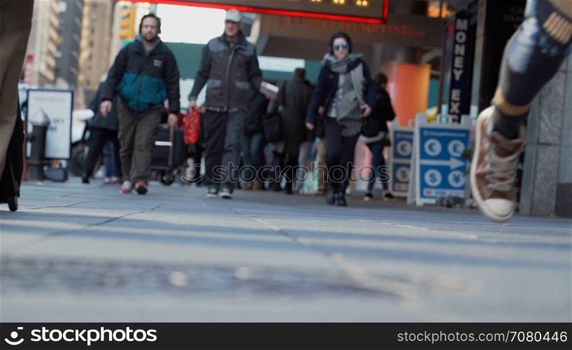 Low angle sidewalk view of people in New York City