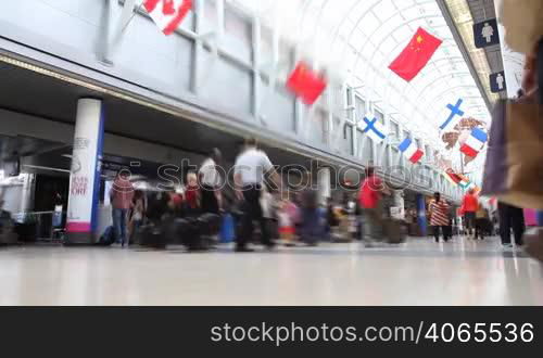 Low angle time lapse of people walking down the terminal of an airport