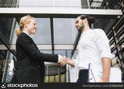 low angle view businessman businesswoman shaking each other hands
