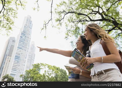 low angle view female holding map hands looking her female pointing something