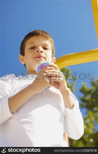 Low angle view of a boy holding an ice-cream and smirking