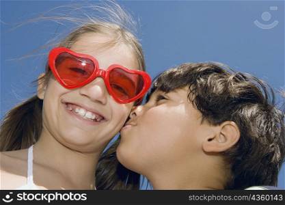 Low angle view of a boy kissing a girl