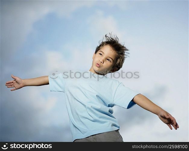 Low angle view of a boy standing with her arm outstretched
