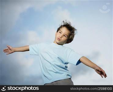 Low angle view of a boy standing with her arm outstretched