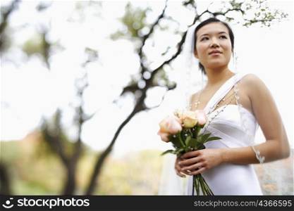 Low angle view of a bride holding a bouquet of flowers