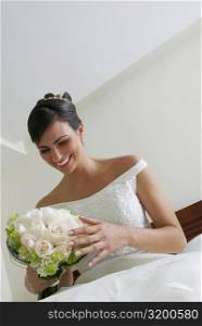 Low angle view of a bride looking at a bouquet of flowers