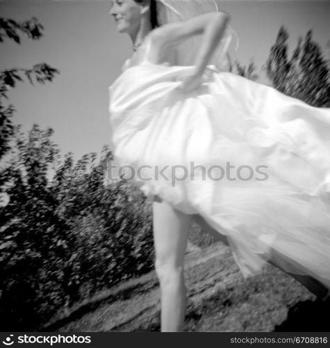 Low angle view of a bride running in a garden