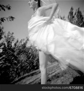 Low angle view of a bride running in a garden
