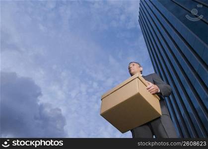 Low angle view of a businessman carrying a box
