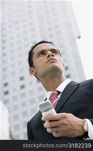 Low angle view of a businessman holding a mobile phone