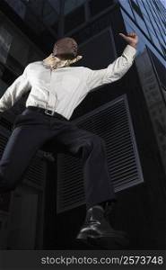 Low angle view of a businessman jumping with a briefcase