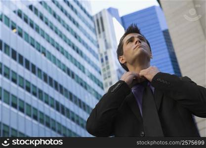 Low angle view of a businessman loosening his tie