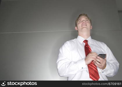 Low angle view of a businessman operating a personal data assistant