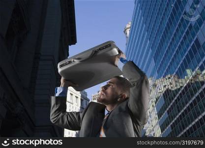Low angle view of a businessman protecting himself with a briefcase