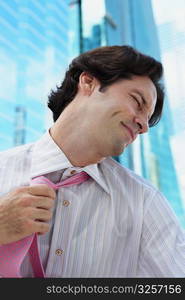 Low angle view of a businessman pulling his tie