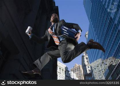 Low angle view of a businessman running in mid-air