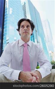 Low angle view of a businessman sitting in front of a building