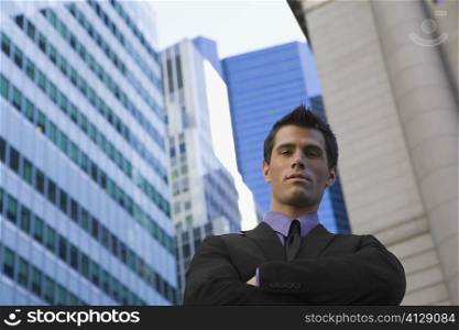 Low angle view of a businessman standing with his arms crossed