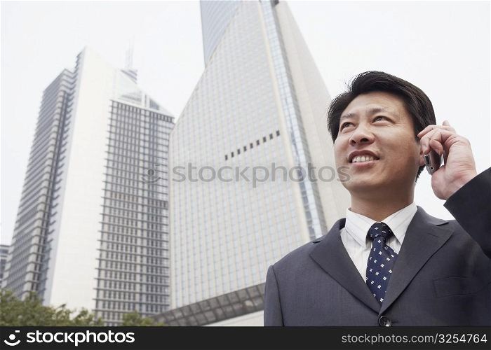 Low angle view of a businessman talking on a mobile phone