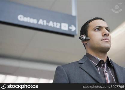 Low angle view of a businessman wearing a hands free device at an airport