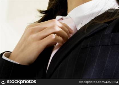 Low angle view of a businesswoman adjusting her tie