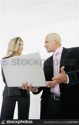 Low angle view of a businesswoman and a businessman using a laptop