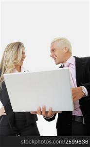 Low angle view of a businesswoman and a businessman using a laptop