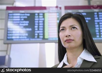 Low angle view of a businesswoman in front of an arrival departure board
