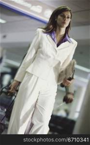 Low angle view of a businesswoman pulling a suitcase