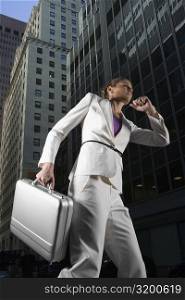 Low angle view of a businesswoman running with a briefcase