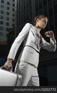 Low angle view of a businesswoman walking and checking the time