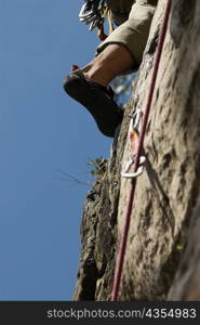 Low angle view of a climbers&acute; leg scaling a rock face